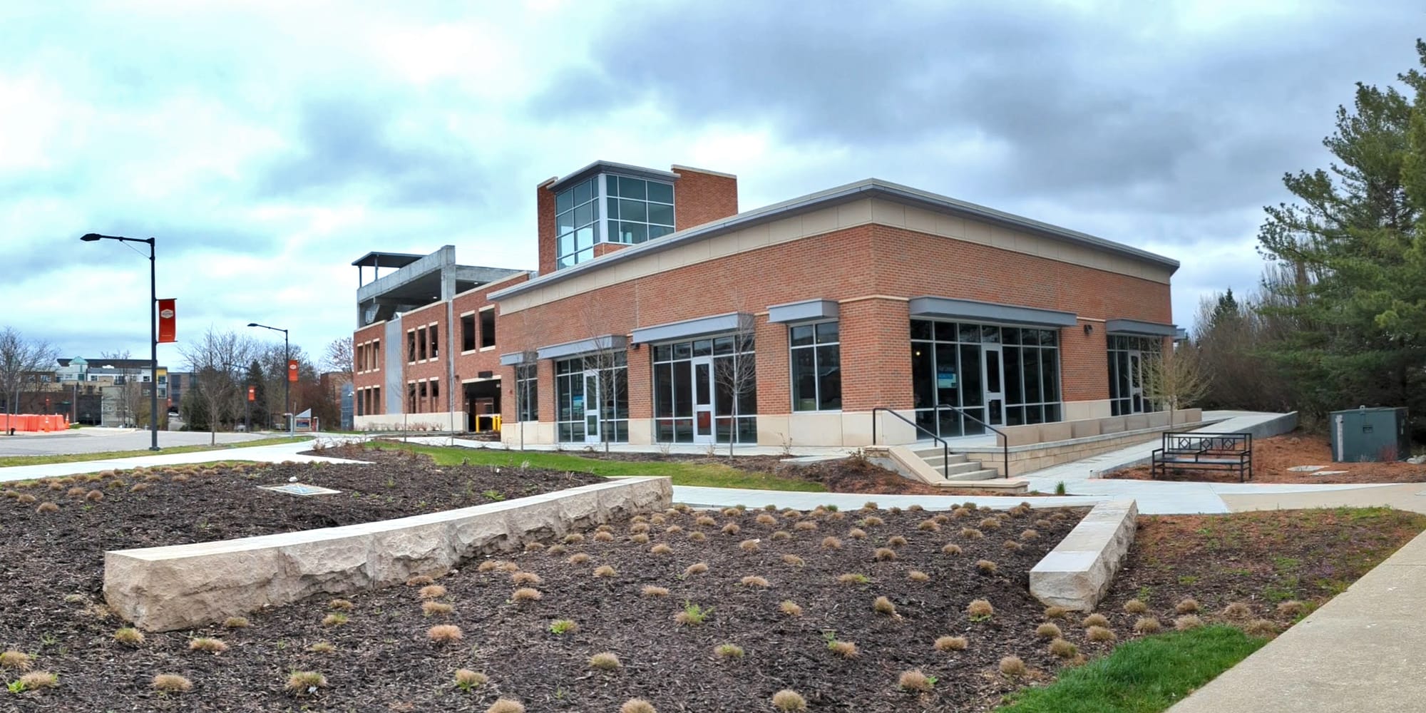 Exterior view of parking garage with commercial space on ground floor fronting street.