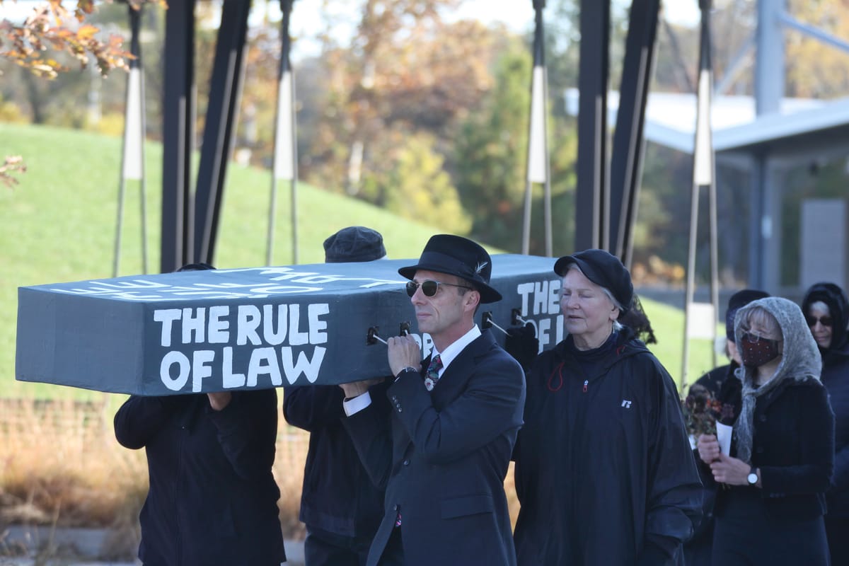 Dirge for democracy: Bloomington protesters stage mock funeral at Switchyard Park