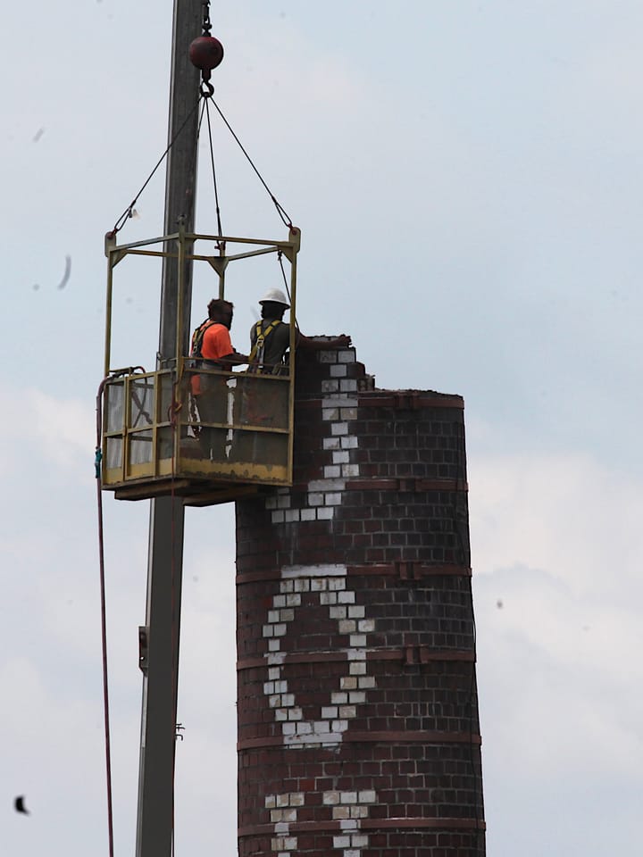 Photos: Brick-by-brick partial demolition of Johnson’s Creamery smokestack starts, as Bloomington watches like a hawk